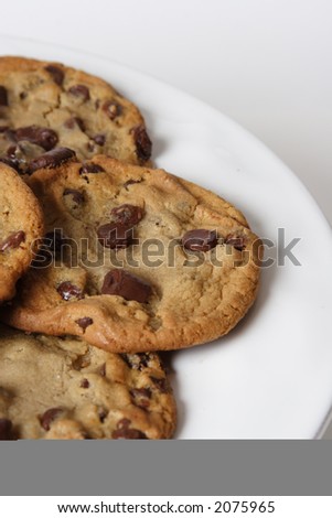 Chocolate Chip Tollhouse Cookies, golden brown with big chuncks of chocolate on a white plate.