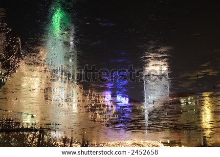 Reflections of buildings and lights in water. Beautiful Colors of blues,yellows greens, peach and gold.