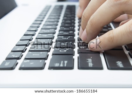 Hand on Keyboard of Notebook