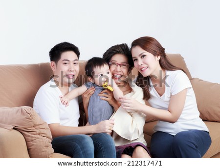 Happy Thai family sitting on the sofa