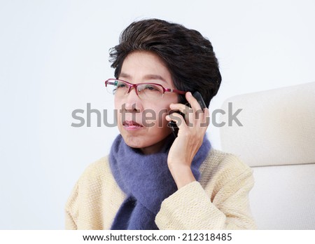 Old Thai woman talking with cell phone sadly face