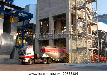 The heavy truck is loading the concrete powder to the packing factory