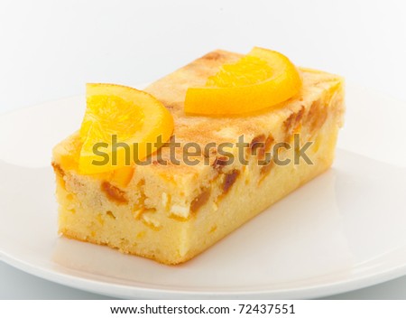 Orange cake melted with pieces of orange and topping on it for decorate
