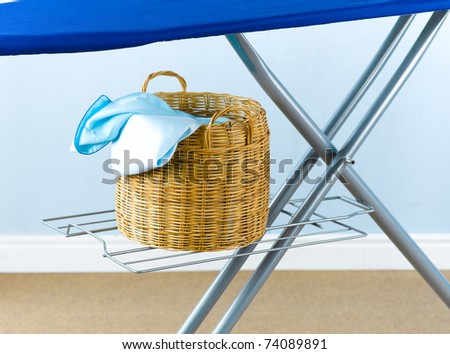 Rattan basket beneath the laundry  board for keeping the wrinkled cloths