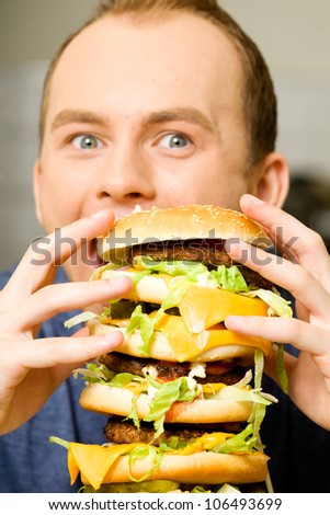 A man eating huge cheeseburger