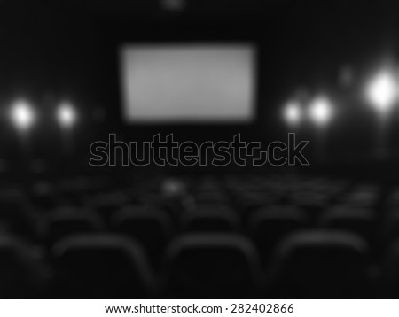 Blurred dark cinema screen room with seats