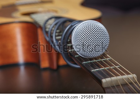 Microphone attached to the guitar neck by cord. Soft focus. Focused only on microphone head.