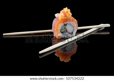 sushi with chopsticks over black background