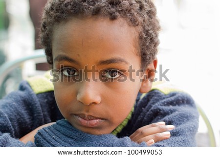 Portrait of a young Ethiopian boy resting his chin on his hands