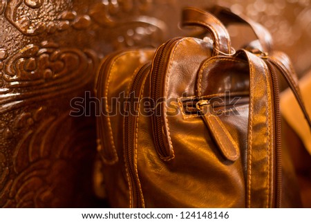 A brown ladies handbag against a brown wooden board