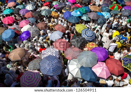 ADDIS ABABA, ETHIOPIA - JANUARY 20: A large crowd with colorful umbrella accompany the Tabot in a colorful procession during Timket celebrations of Epiphany, on January 20, 2013 in Addis Ababa, Ethiopia.