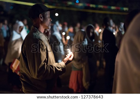 ADDIS ABABA, ETHIOPIA - JANUARY 19: A large crowd of people pray with candle light during Timket (baptism in Amharic) celebrations  on January 19, 2013 in Addis Ababa.