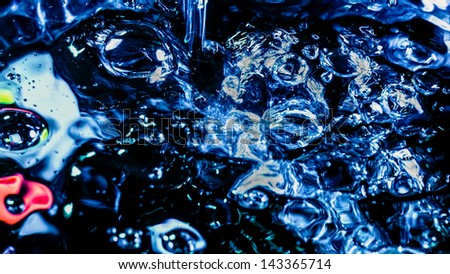 Fluid motion of splashing water and bubbles forming abstract alien figures