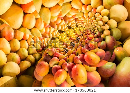 Repeating pattern of a pile of ripe mangos on a fruit stand