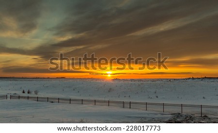 The sun setting on the vast snow covered flat lands of Saskatchewan Province in Canada.
