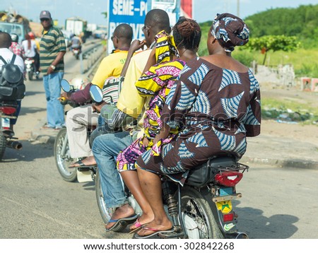 Cotonou, Benin: May 26:  People hire motorcycle taxis to move around in the city of Benin, one of the most common means of hired transportation in the city, on May 26, 2015 in Cotonou, Benin.