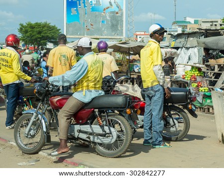 Cotonou, Benin: May 26: A man rides a Motorcycle taxi, the most common means of hired transportation in the city, on May 26, 2015 in Cotonou, Benin.