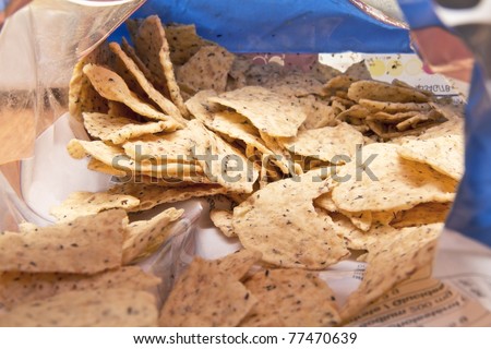 Taking a sneak peak into a bag of corn tortilla chips