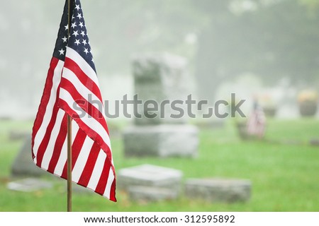 American veteran flag in a foggy cemetery. Vertical format.