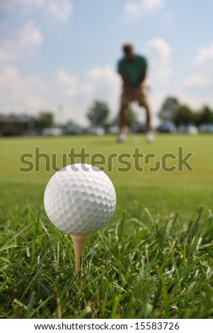Golf Ball and Golfer Against Blue Sky
