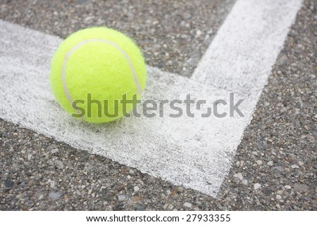 Tennis Ball on Line Close-up of tennis ball on white court line. Horizontal format.