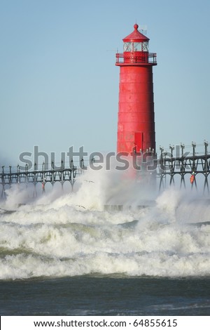 Waves crashing on lighthouse. Grand Haven lighthouse on Lake Michigan. Vertical format.