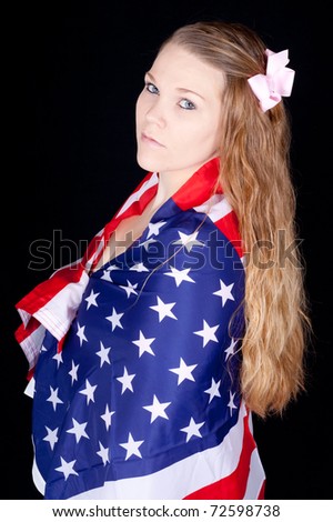 A serious woman with a flag drapped around her.  She does not take her liberty lightly.