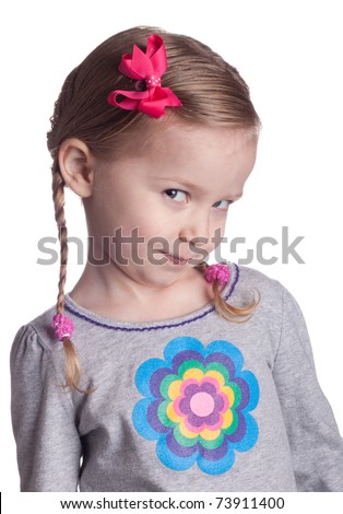 A young girl looks up and to the side at the viewer.  She could be posing a question, thinking or just being cute.