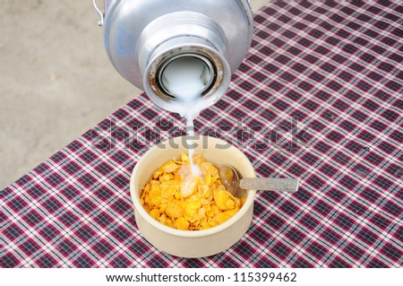 Breakfast with milk pouring in corn flakes