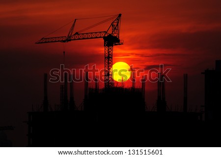 Silhouettes Office buildings construction site and crane with the sunset