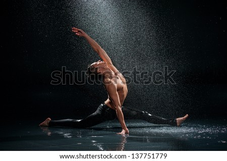 Dancing man under rain. Photo in a studio