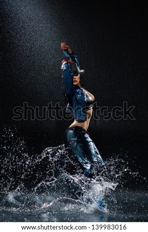 Wet dancing woman. Under waterdrops. Studio photo