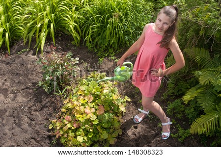 Cute girl watering plants in a garden