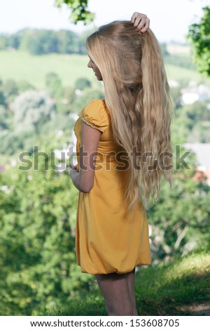 Girl in yellow dress against rural landscape background