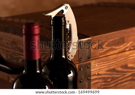 Wooden case with two bottles of red wine with corkscrew