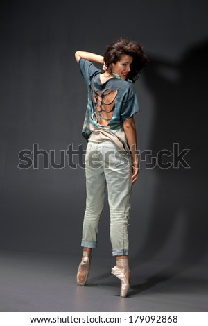 Sexy woman dancing in pointes modern dance. Photo in a studio. Hands up