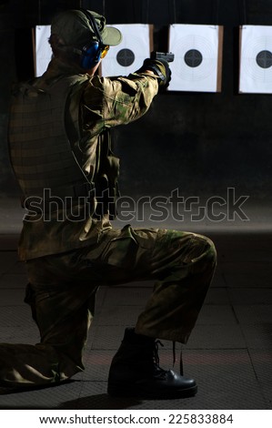 Man shooting with gun at a target in shooting range