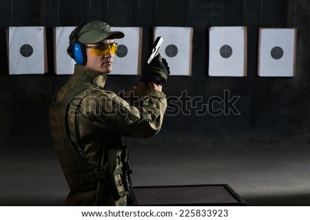 Man shooting with gun at a target in shooting range