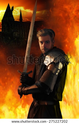 Ancient knight in metal armor with sword on a fiery background