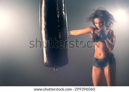 Boxing training woman sparring punching bag in gym wear gloves