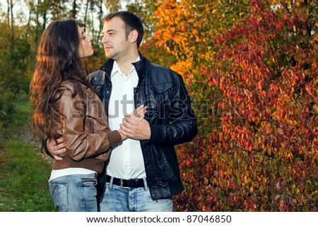 A young couple on a date on the background of yellow autumn leaves