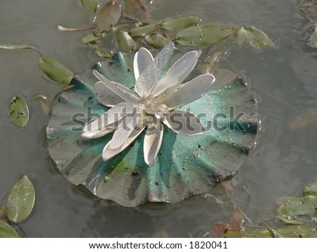 Artificial electric water lily with dragon-fly, close-up