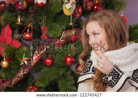 Beautiful woman hanging toy on Christmas tree