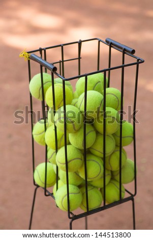 Basket with tennis balls on a court