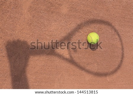 shadow of a tennis player in action on a tennis court
