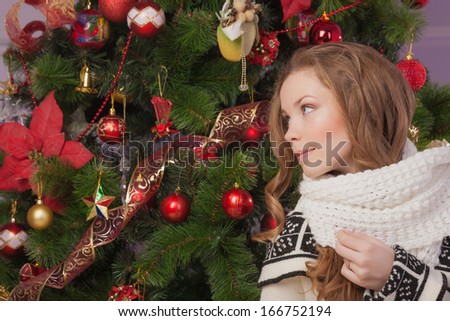 Beautiful girl hanging toy on Christmas tree