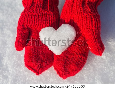 snowflake in the form of heart on red mittens
