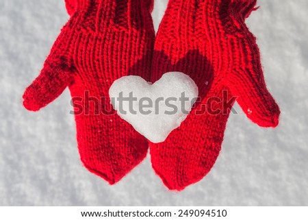 snowflake in the form of heart on red mittens