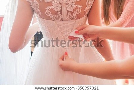 Helping the bride to put her wedding dress on