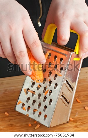 Hand holding carrot vegetable food kitchen grater